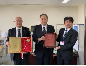 上場通知書を持つ南條社長(中央)、安齋商工労働部長(右)、上場記念の小づちを持つ遠藤 管理本部部長(左)